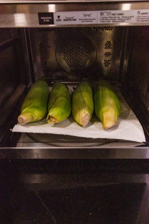 Fresh corn on the cob in the microwave oven ready for cooking.