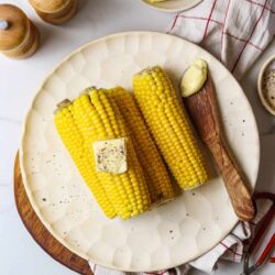 Fresh grilled corn on the cob with butter and black pepper, ready to serve.