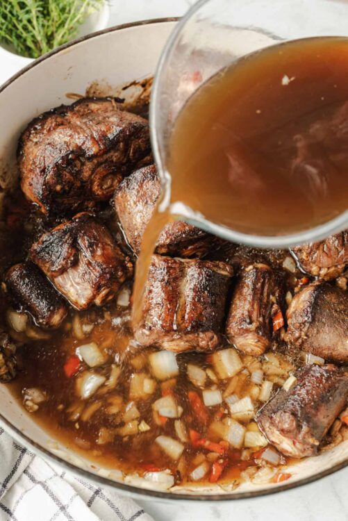 Savory beef short ribs braised in broth with onions and vegetables, cooked to perfection.