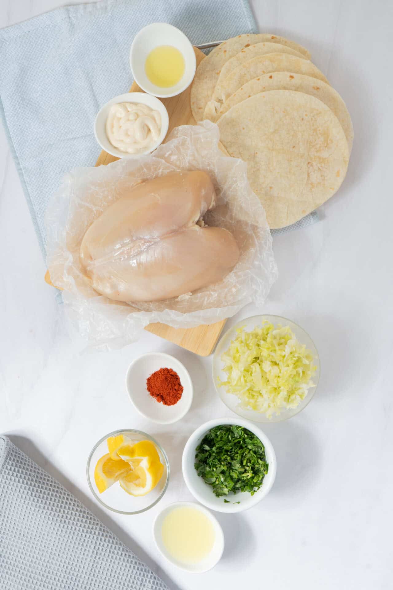 Boneless chicken breast with taco ingredients including tortillas, guacamole, sour cream, shredded cheese, and spices.