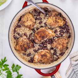 Savory chicken and rice casserole with beans in a white cast iron skillet.