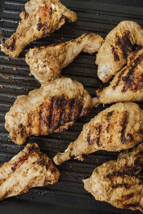 Grilled chicken drumsticks on a black grill pan, showcasing juicy, flavorful, and perfectly cooked baked chicken recipes.