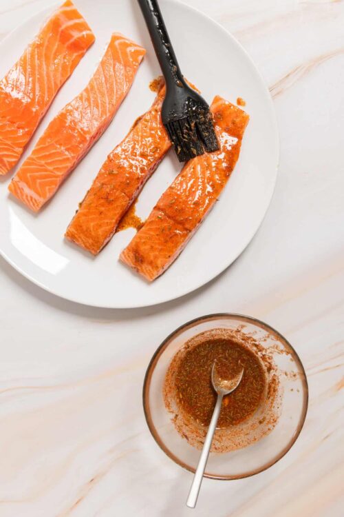 Succulent salmon fillets with flavorful marinade on a white plate.