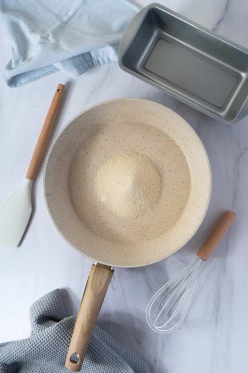 Flour in a mixing bowl with baking tools and baking sheet for baking bread or cake.