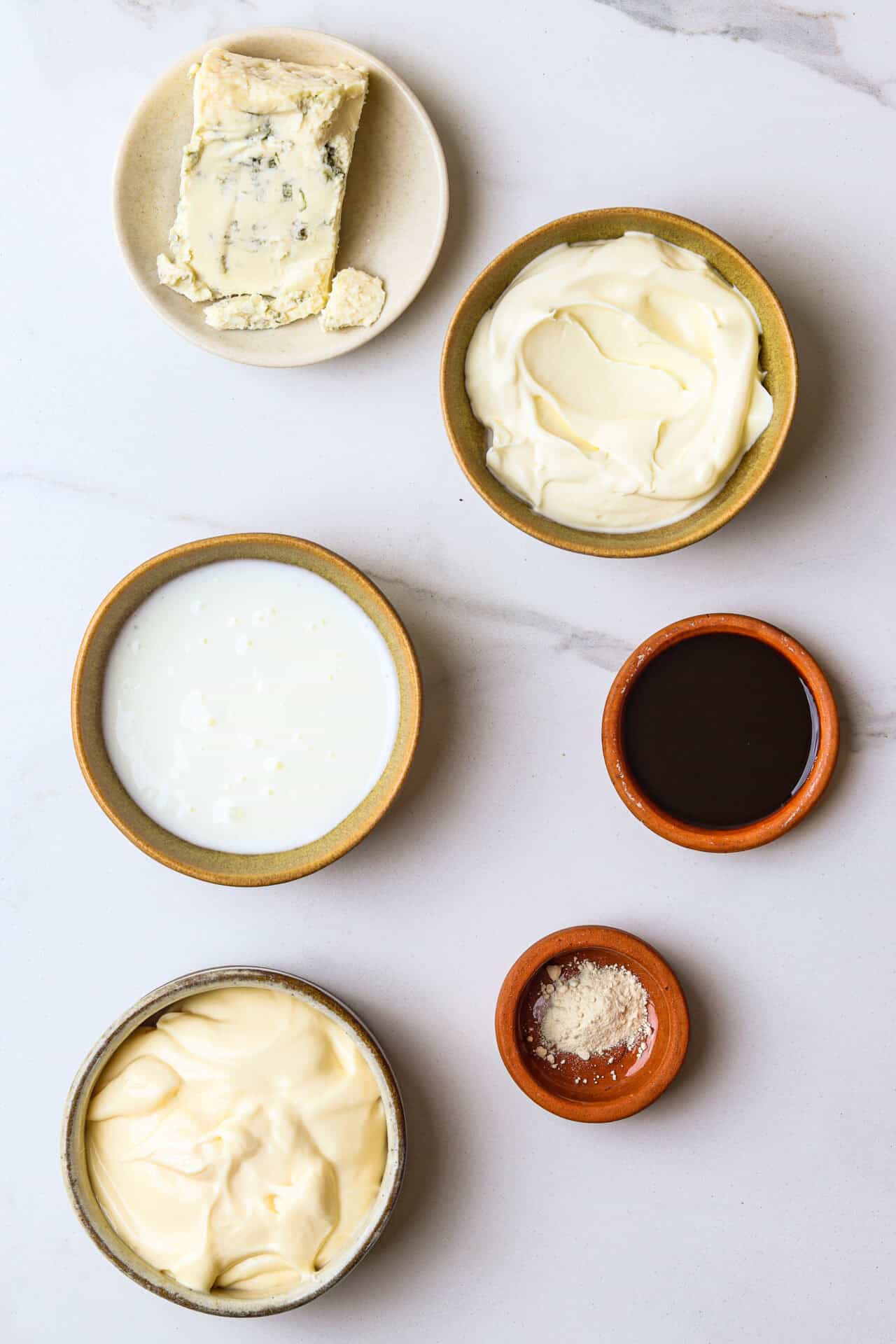 Buttery blue cheese and creamy soft cheeses with condiments and seasonings for cheese platter.