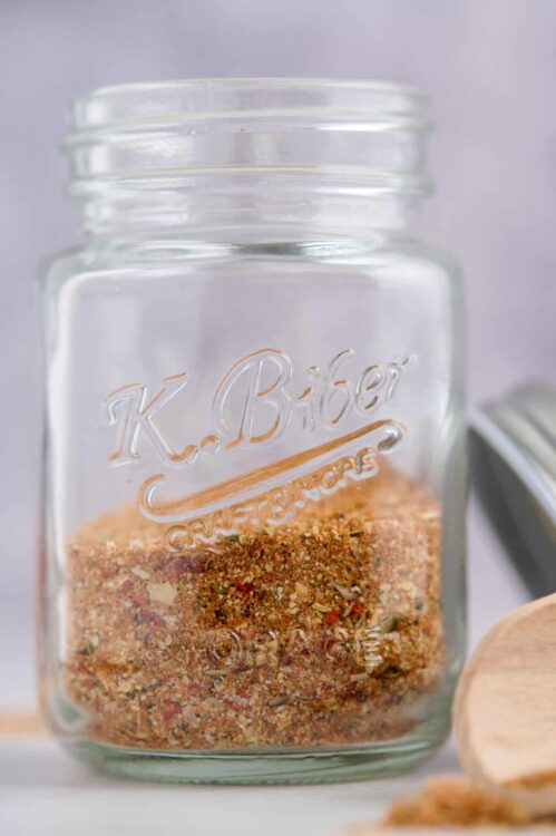 Ground spice mix in a vintage K. Bieger glass jar on a kitchen countertop.