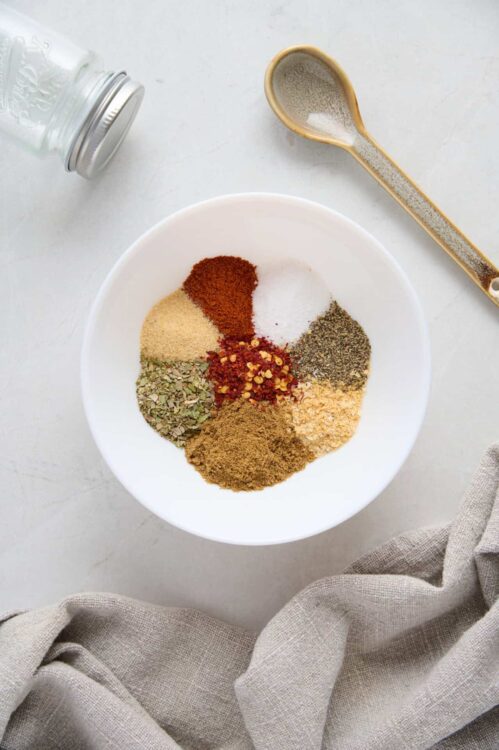 Ground spices in a white bowl for baking and cooking. Various herbs and spices ready for recipe preparation.