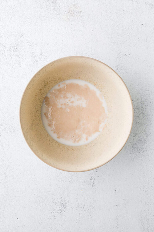 Cream of milk in a beige ceramic bowl for baking or cooking recipes.