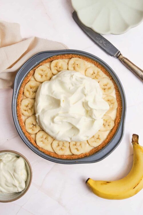 Creamy banana cream pie with whipped topping and fresh banana slices, perfect for baking enthusiasts.