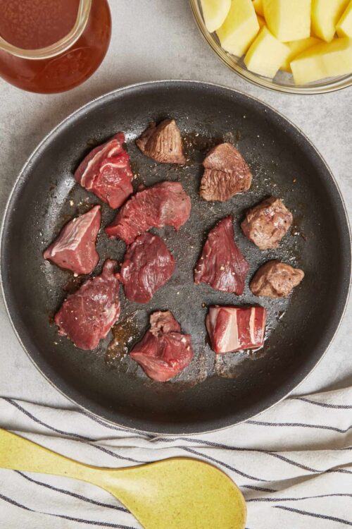Juicy beef chunks browning in a skillet for a delicious recipe.