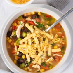 Comforting chicken tortilla soup with fresh vegetables and cheese, perfect for cozy homemade meals.