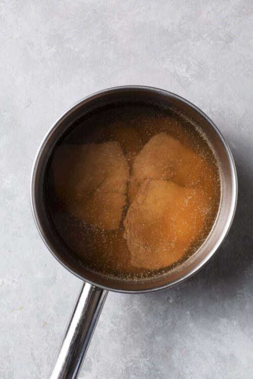 Buttered toast in a saucepan soaking in butter.
