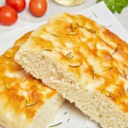 Fluffy homemade focaccia bread topped with rosemary and olive oil, perfect for baking and bread recipes.