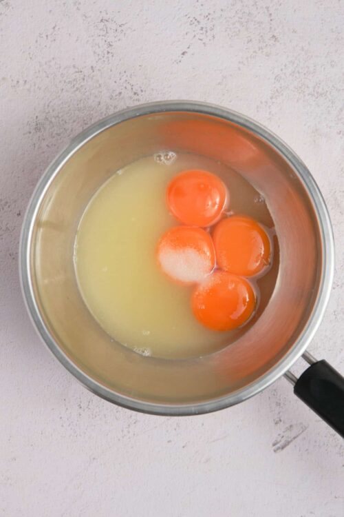 Whisked eggs in a metal bowl for baking recipes, breakfast, or smoothies.