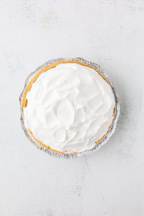 Sweet potato pie with whipped topping in foil pie crust, baked dessert.