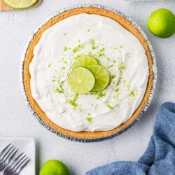 Lime pie with creamy topping and sliced limes on top.