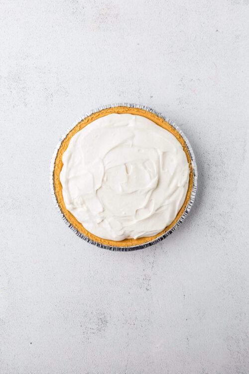 Freshly baked pie with vanilla frosting on a white background.