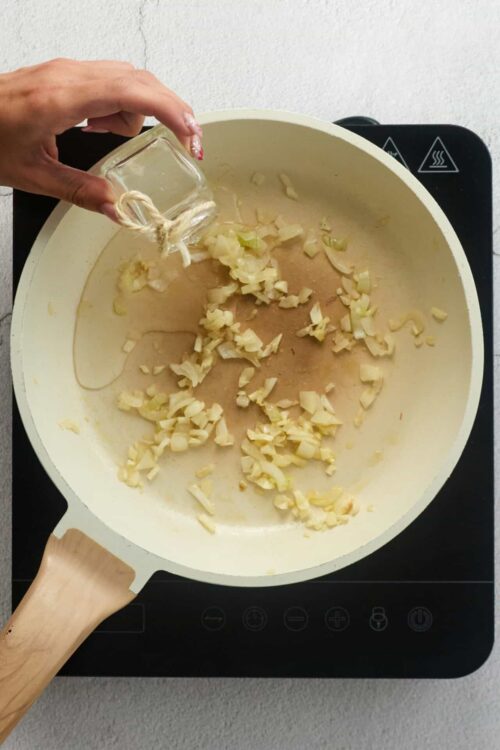 Chopped onions sautéing in a skillet for cooking recipes.