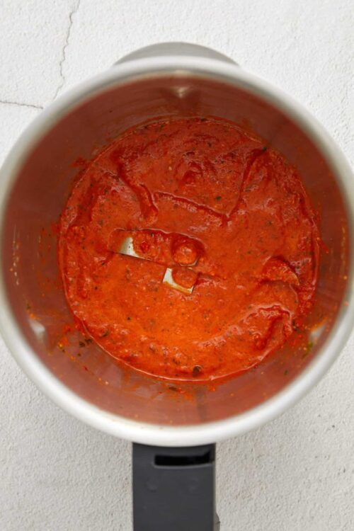 Spaghetti sauce in a white mug, ready for cooking or serving.