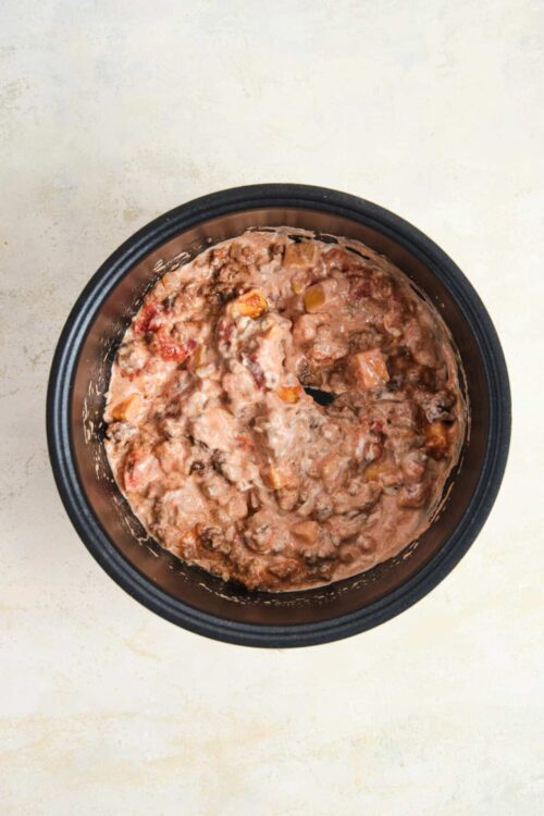 Creamy beef and vegetable stew in a black slow cooker. Perfect comfort food, easy to make, hearty, and flavorful. Ideal for dinner or meal prep.