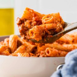 Savory baked pasta with meat sauce on spoon, cheesy baked ziti with ground beef, close-up of baked pasta with rich tomato sauce and melted cheese, perfect for comfort food lovers.
