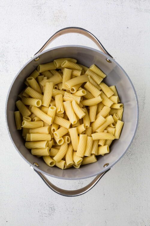 Cooked rigatoni pasta in a stainless steel pot for homemade pasta recipes.