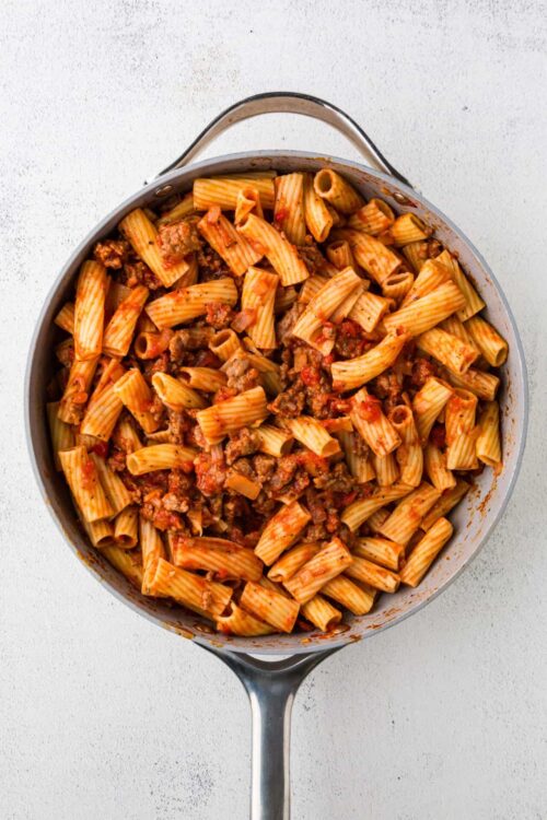 Baked pasta with meat sauce in a skillet, home-cooked Italian comfort food.