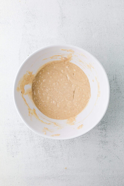 Baked Bree banana bread batter in a white mixing bowl.