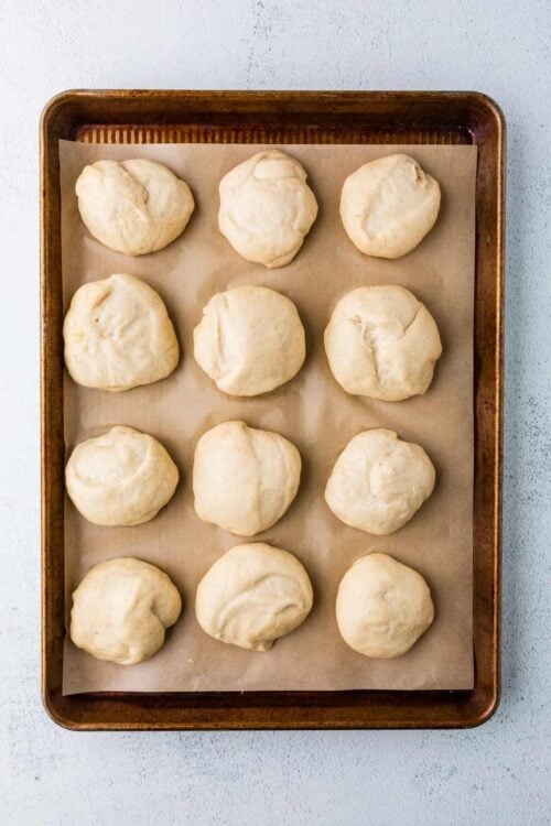 Cream cheese biscuit dough balls on baking sheet for homemade baked goods.