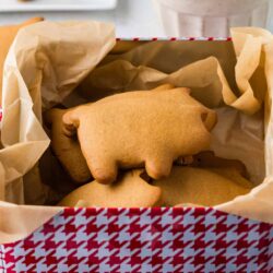 Freshly baked animal-shaped sugar cookies in a gift box with parchment paper, perfect for holiday treats and baking gifts.