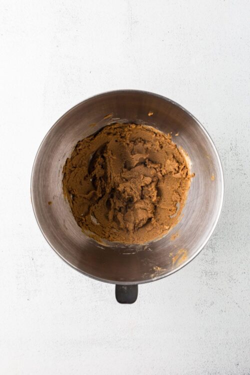 Creamy brown cookie dough in a mixing bowl for baking recipes.