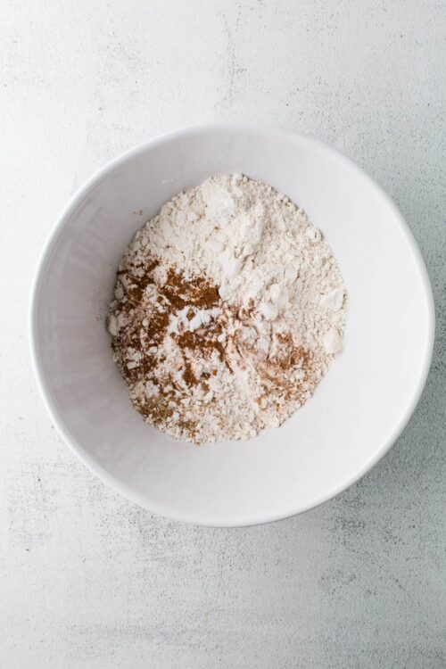 Flour and cocoa powder mixture in a white bowl for baking.