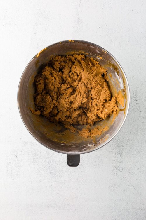 Creamy pumpkin pie dough in mixing bowl for fall baking recipes.