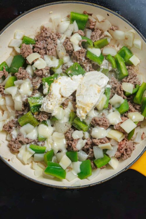 Savory ground beef with green bell peppers and melted cheese in a skillet.