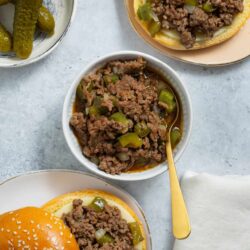 Savory cheeseburger sliders with cooked ground beef and pickles in a sandwich bun.