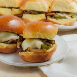 Savory cheeseburger sliders with melted cheese and fresh toppings on soft dinner rolls.