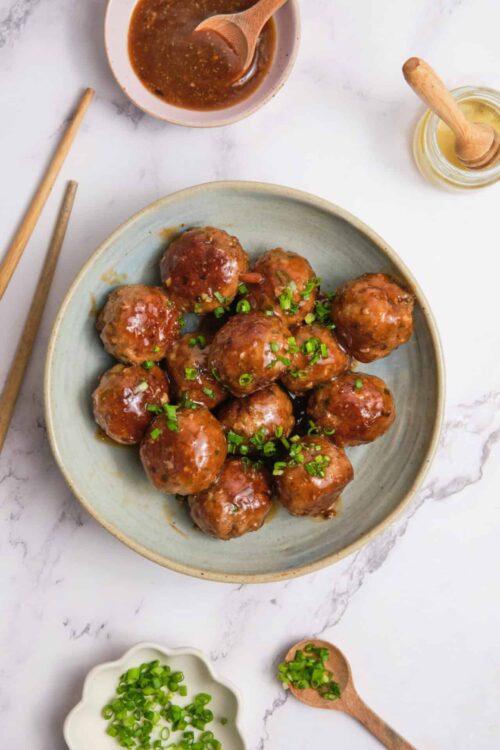 Savory homemade meatballs with brown sauce on a ceramic plate.