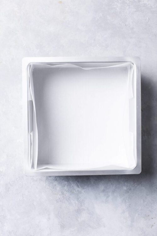 Unlined metal baking pan with parchment paper, ready for baking or cooking.