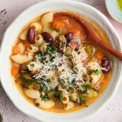 Creamy vegetable and pasta soup with beans, cheese, and herbs.