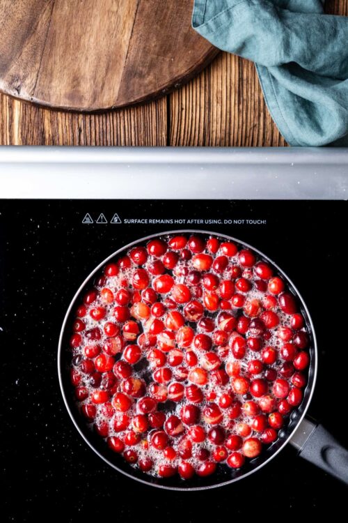 Fresh cranberries boiling on a stovetop for holiday recipes.