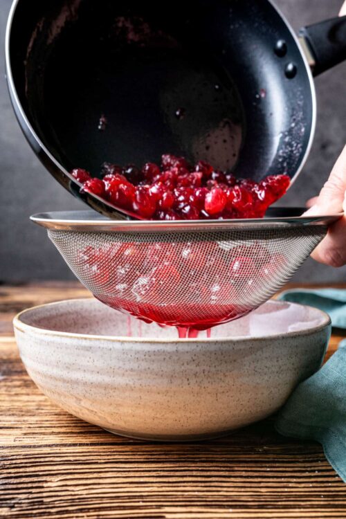 Fresh cherries being strained over a bowl for baking or cooking.