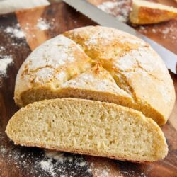 Sweet Italian bread with a crisp crust and soft interior on a wooden cutting board. Perfect for sandwiches or toast.