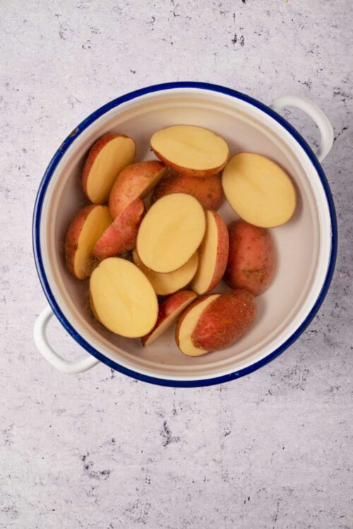 Juicy red potatoes soaking in water for baking or cooking.