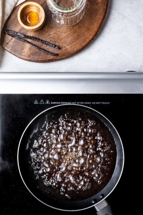 Butter melting in a black skillet on stovetop, close-up view.