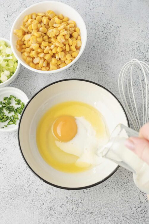 Soft scrambled eggs with canned corn, green onions, and milk ingredients for breakfast or brunch.