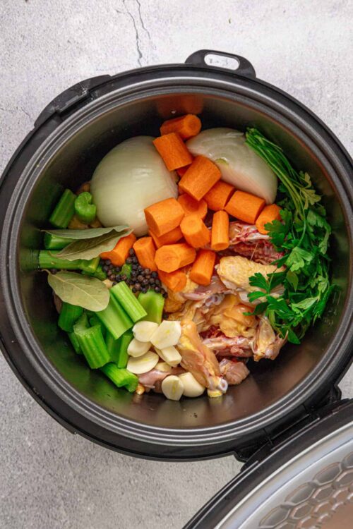 Fresh vegetables and chicken in a slow cooker for delicious homemade stew.