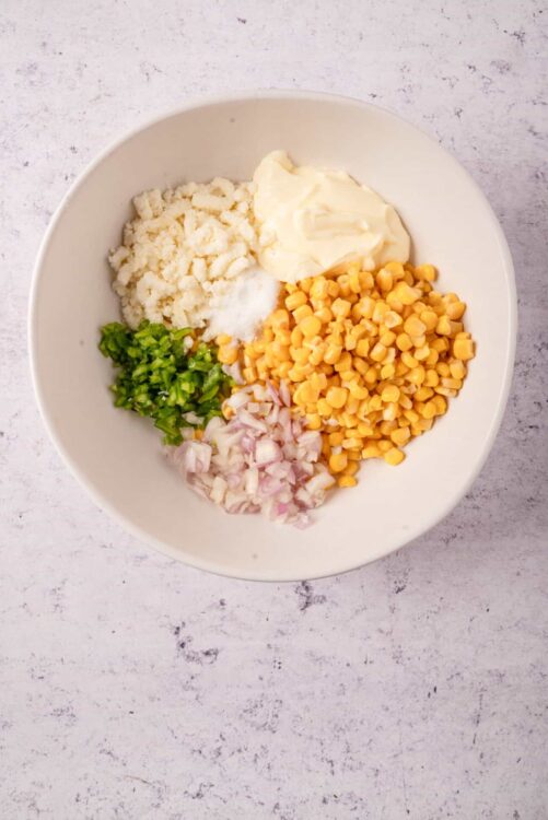 Creamy mashed potato ingredients in a white bowl ready for cooking.