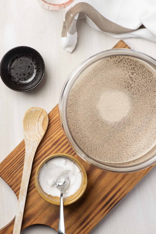 Flour and baking ingredients on a wooden board for baking bread.