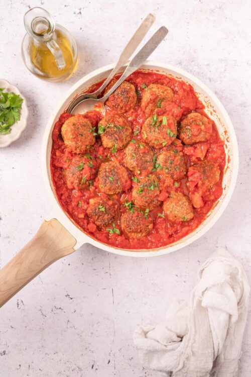 Savory Italian meatballs in tomato sauce served in a white skillet. Perfect for comfort food and family dinners.