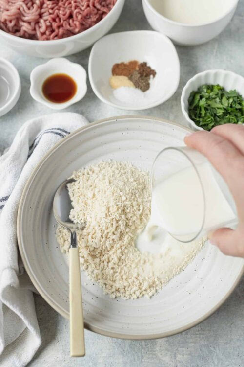 Cream being poured into a bowl of shredded cheese for homemade baked goods.